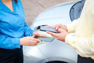 two people with phones out exchanging information after car accident