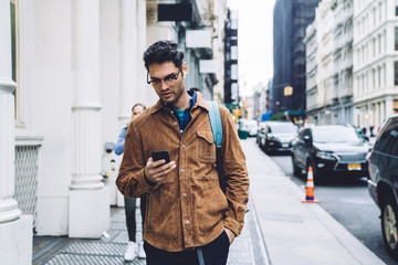 man texting while walking on street